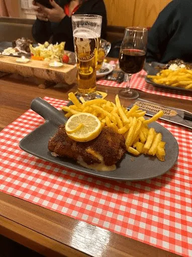 Schnitzel mit Pommes frites und Zitrone auf rot-weiss karierter Tischdecke