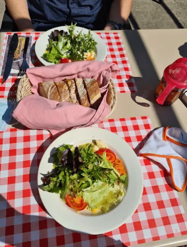 Gedeckter Tisch mit Salat und Brot auf rot-weiss karierter Tischdecke