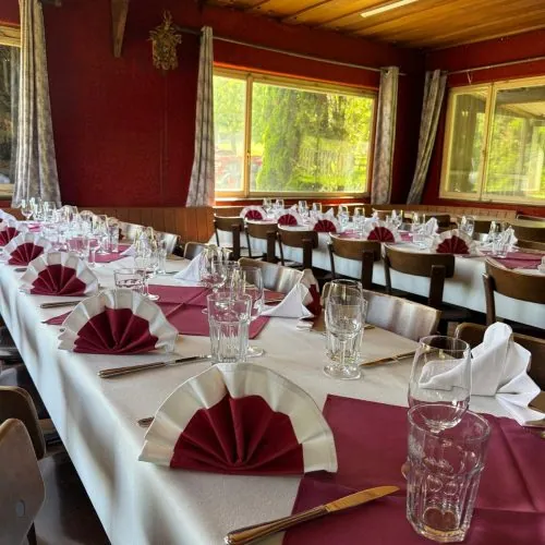 Festlich gedeckte Tische mit roten Servietten im Saal