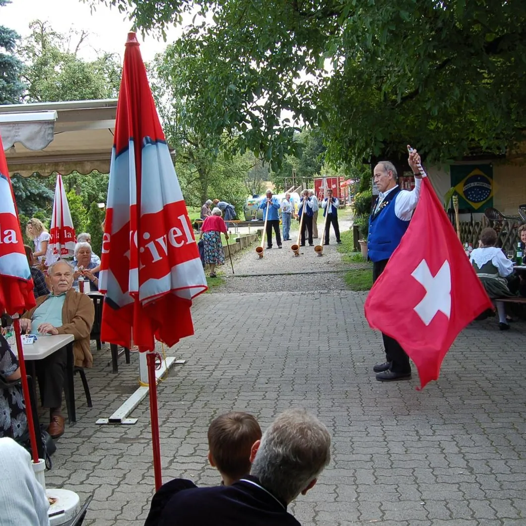 Fahnenschwinger mit Schweizer Fahne vor dem Restaurant